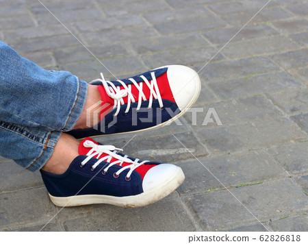 Feet sneakers in the park on the bench 62826818