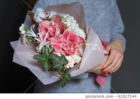 Girl holds in her hands original bouquet in 62827244