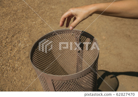 Hand of woman throwing waste in a trash can at Merida Hand of woman throwing waste in a trash can at Merida 62827470
