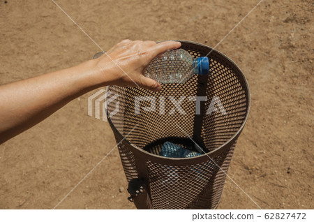 Hand of woman throwing a plastic bottle in a trash can at Merida Hand of woman throwing a plastic bottle in a trash can at Merida 62827472
