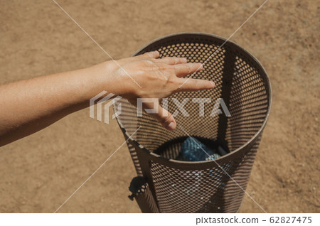 Hand of woman throwing a plastic bottle in a trash can at Merida Hand of woman throwing a plastic bottle in a trash can at Merida 62827475