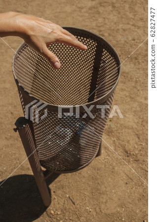 Hand of woman throwing a plastic bottle in a trash can at Merida Hand of woman throwing a plastic bottle in a trash can at Merida 62827477