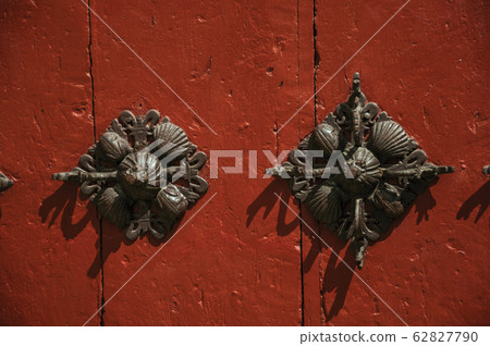 Iron studs attached to wooden planks in an old door 62827790