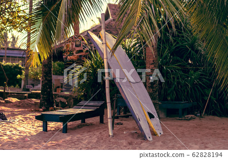Surfboards resting on a wooden stand in the sand 62828194