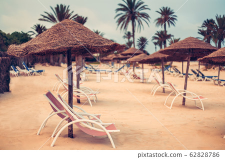 Focus on parasol. Sunbeds on snow-white sand Focus on parasol. Sunbeds on snow-white sand 62828786