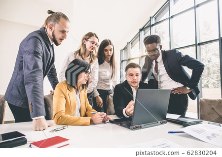 Business meeting of multinational managing team with laptops in office. Multiethnical group of business people having a business meeting 62830204