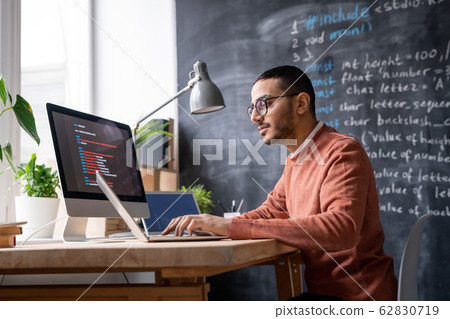 It-manager sitting in front of laptop in office and analyzing coded information 62830719
