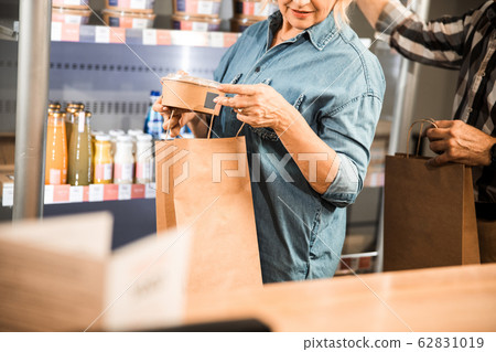 Adult woman holding products in the store 62831019