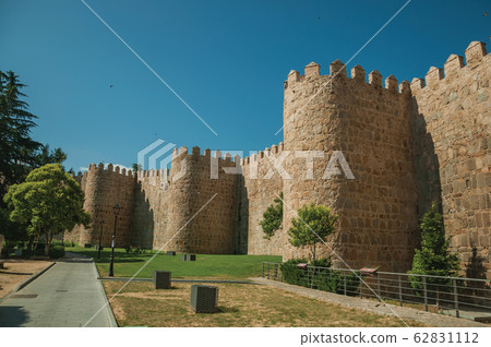 Several towers on the city wall and green garden in Avila 62831112