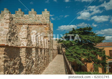 Pathway over old thick wall with large tower in Avila Pathway over old thick wall with large tower in Avila 62831745