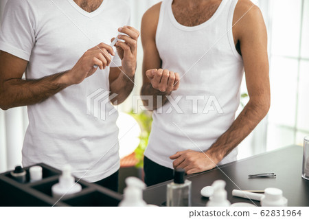 Young man using nail file in the morning Young man using nail file in the morning 62831964