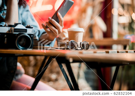 Cropped photo of female hand with mobile phone outdoors 62832104