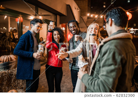 Happy friends greeting their male friend in the city 62832300