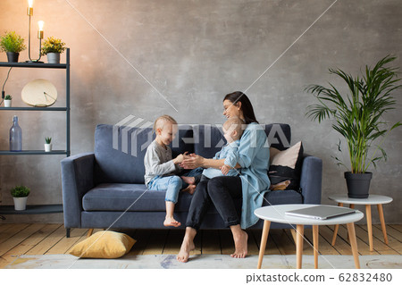 Young Mother Playing with Children on the Couch. happy family. home comfort. Young Mother Playing with Children on the Couch. happy family. home comfort. 62832480