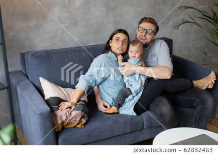 Young Family Playing Together on the Sofa. happy family. home comfort. 62832483
