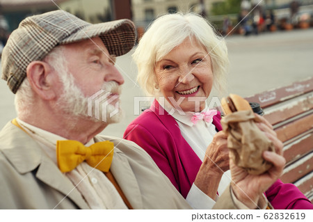 Happy mature lady having meal with husband outdoors 62832619