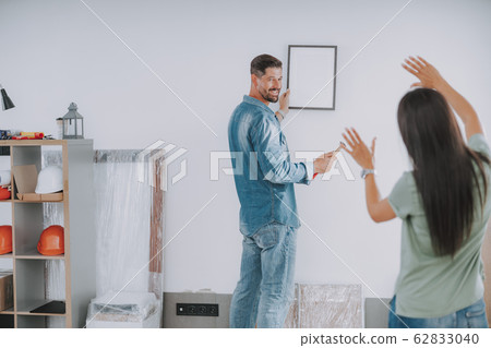 Happy man is holding hammer and frame Happy man is holding hammer and frame 62833040