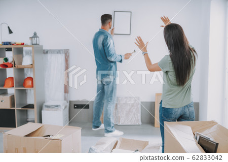 Young couple discussing how to hang a picture 62833042