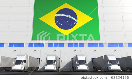 Modern trailer trucks load or unload at warehouse docks with flag of BRAZIL. Brazilian logistics related conceptual 3D rendering Modern trailer trucks load or unload at warehouse docks with flag of BRAZIL. Brazilian logistics related conceptual 3D rendering 62834126