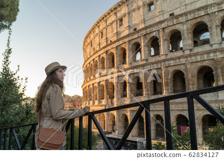 Roman Holiday. Portrait of happy young woman in the front of Colosseum in Rome, Italy Roman Holiday. Portrait of happy young woman in the front of Colosseum in Rome, Italy 62834127