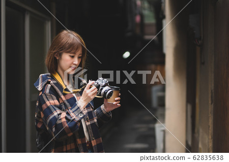A young woman traveling alone downtown with a camera A young woman traveling alone downtown with a camera 62835638