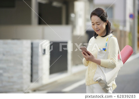 Active senior woman smartphone yoga 62839283