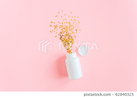 Gold stars confetti fly out white medical bottle Gold stars confetti fly out white medical bottle 62840325