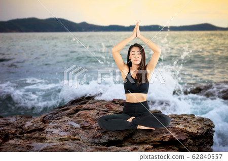 Attractive smiling woman practicing yoga on the Attractive smiling woman practicing yoga on the 62840557