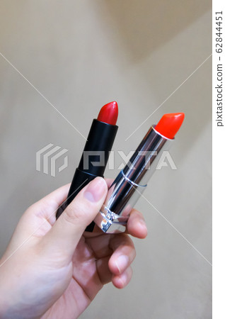 日本女人的手，握著一支紅色和橙色的口紅 62844451