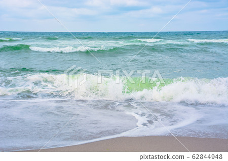 waves crash on sandy beach waves crash on sandy beach 62844948