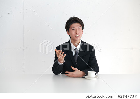 一個自我介紹並在主要話題面前講話的商人 62847737