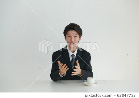 一個自我介紹並在主要話題面前講話的商人 62847752