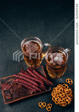light beer and variety of meat delicatessen 62848598