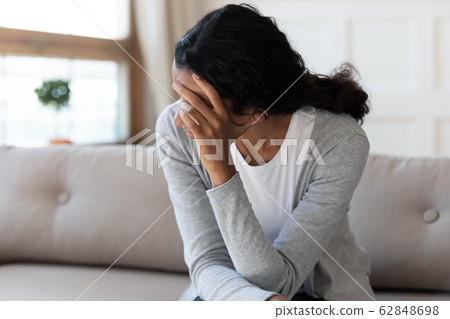 Unhappy biracial woman look in distance feeling depressed 62848698