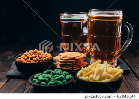 two mugs of lager and salty traditional appetizers 62849144
