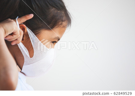 Cute asian child girl wearing protection mask to against air smog pollution with PM 2.5 Cute asian child girl wearing protection mask to against air smog pollution with PM 2.5 62849529