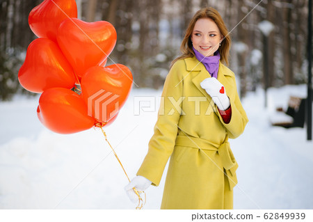beautiful lady in coat with air balloons 62849939