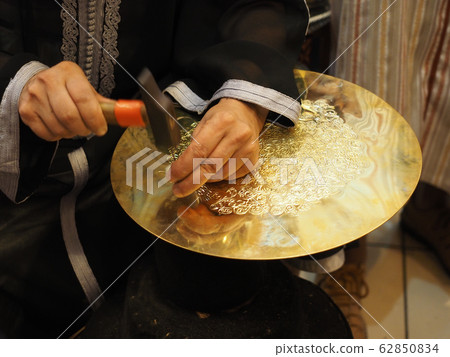 Hands of a craftsman applying silverwork in Fes, Morocco Hands of a craftsman applying silverwork in Fes, Morocco 62850834