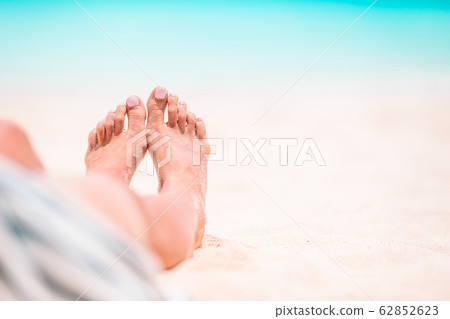 Woman's feet on the white sand beach in shallow water Woman's feet on the white sand beach in shallow water 62852623