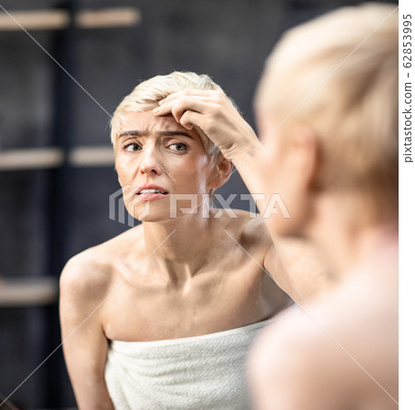 Concerned Lady Looking At Wrinkles Standing In Bathroom Indoor Concerned Lady Looking At Wrinkles Standing In Bathroom Indoor 62853995