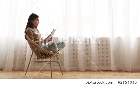 Morning vibes. Girl reading e-book on tablet 62854089