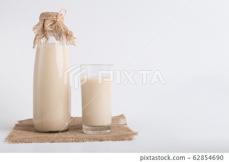 Soy milk in bottle and glass on linen cloth 62854690