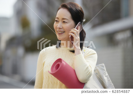 活躍的高級女子智能手機瑜伽 62854887
