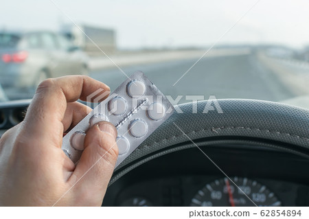 View of the driver hand holding a bag of pills View of the driver hand holding a bag of pills 62854894