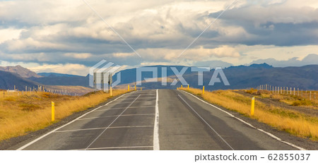 Iceland road landscape with clouds and emply field Iceland road landscape with clouds and emply field 62855037