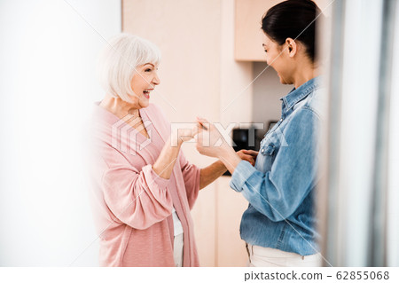 Happy grandmother and adult granddaughter having fun at home Happy grandmother and adult granddaughter having fun at home 62855068