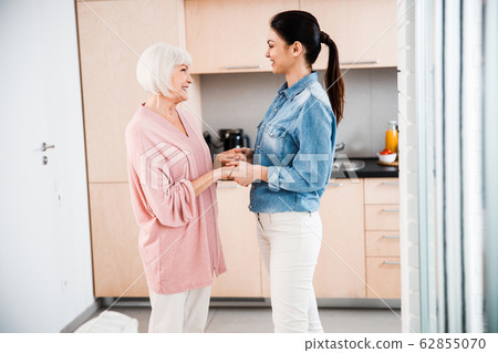 Happy grandmother and adult granddaughter holding hands Happy grandmother and adult granddaughter holding hands 62855070