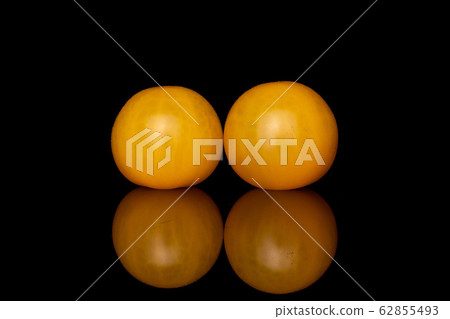 Fresh yellow tomato isolated on black glass Fresh yellow tomato isolated on black glass 62855493