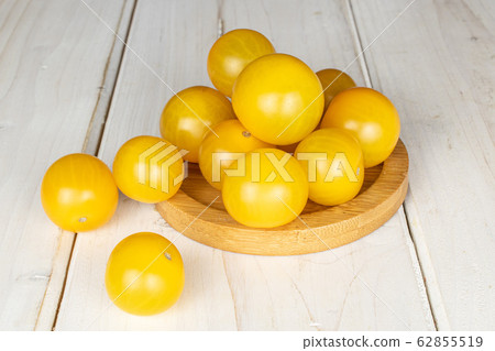 Fresh yellow tomato on grey wood 62855519
