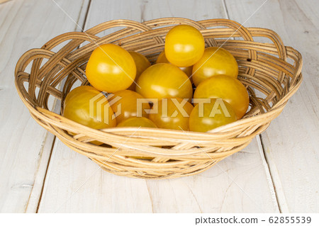 Fresh yellow tomato on grey wood 62855539